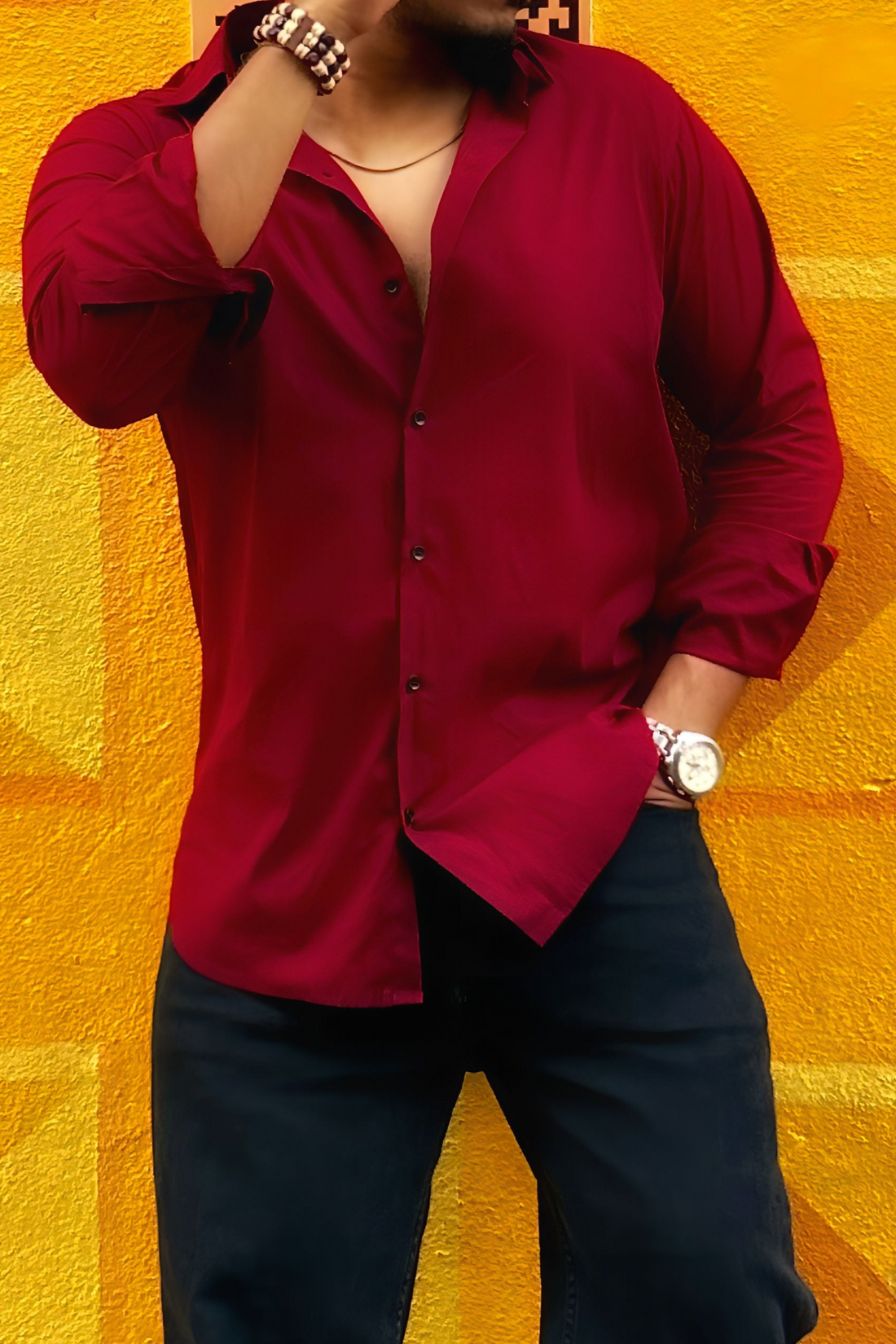 a man standing in front of a yellow wall talking on a cell phone