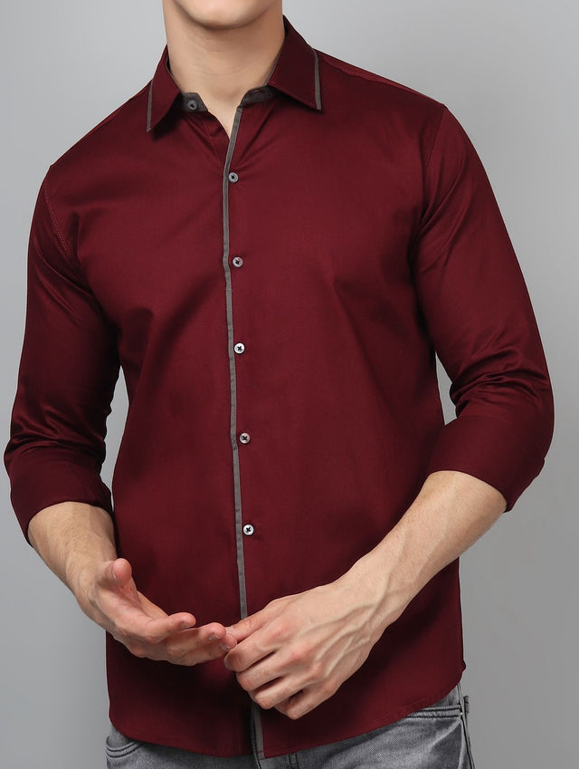 
a man in a red shirt is holding his hands together
