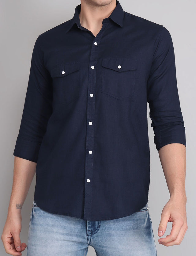 
a man wearing a blue shirt and jeans
