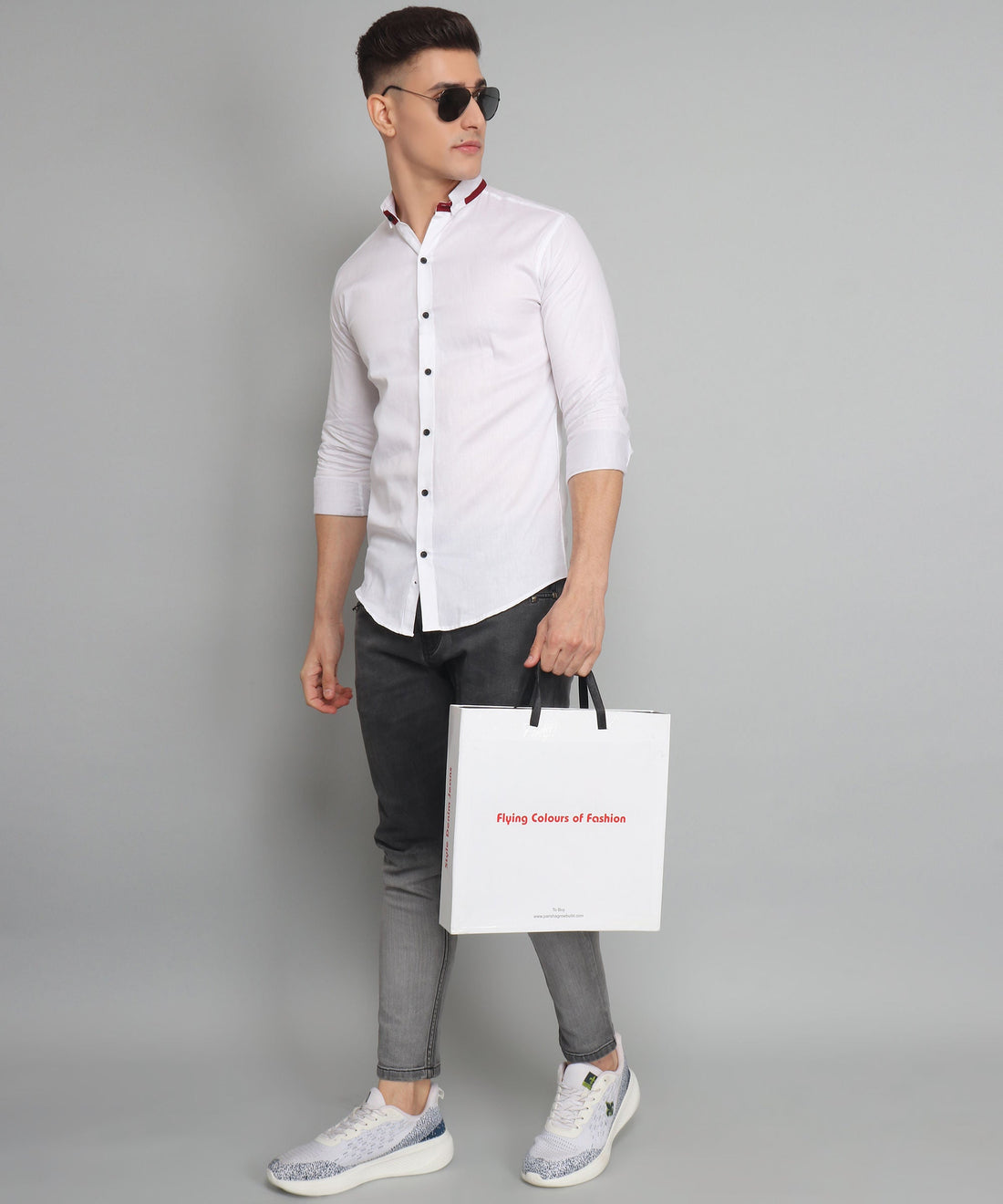 
a man holding a shopping bag and wearing sunglasses
