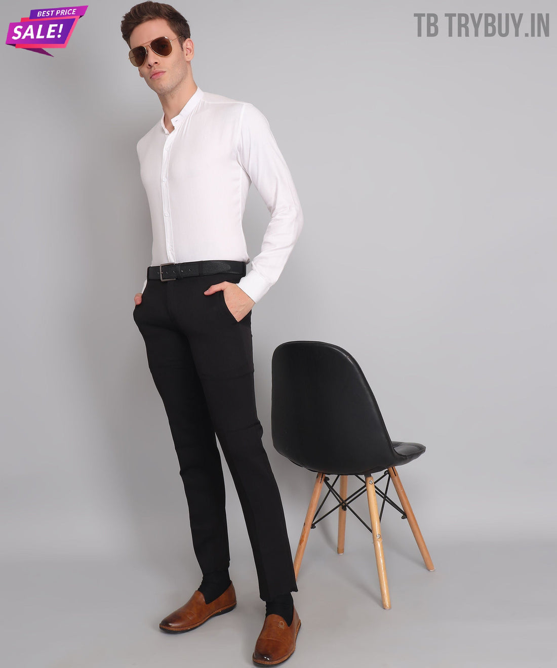 
a man in a white shirt and black pants standing next to a chair
